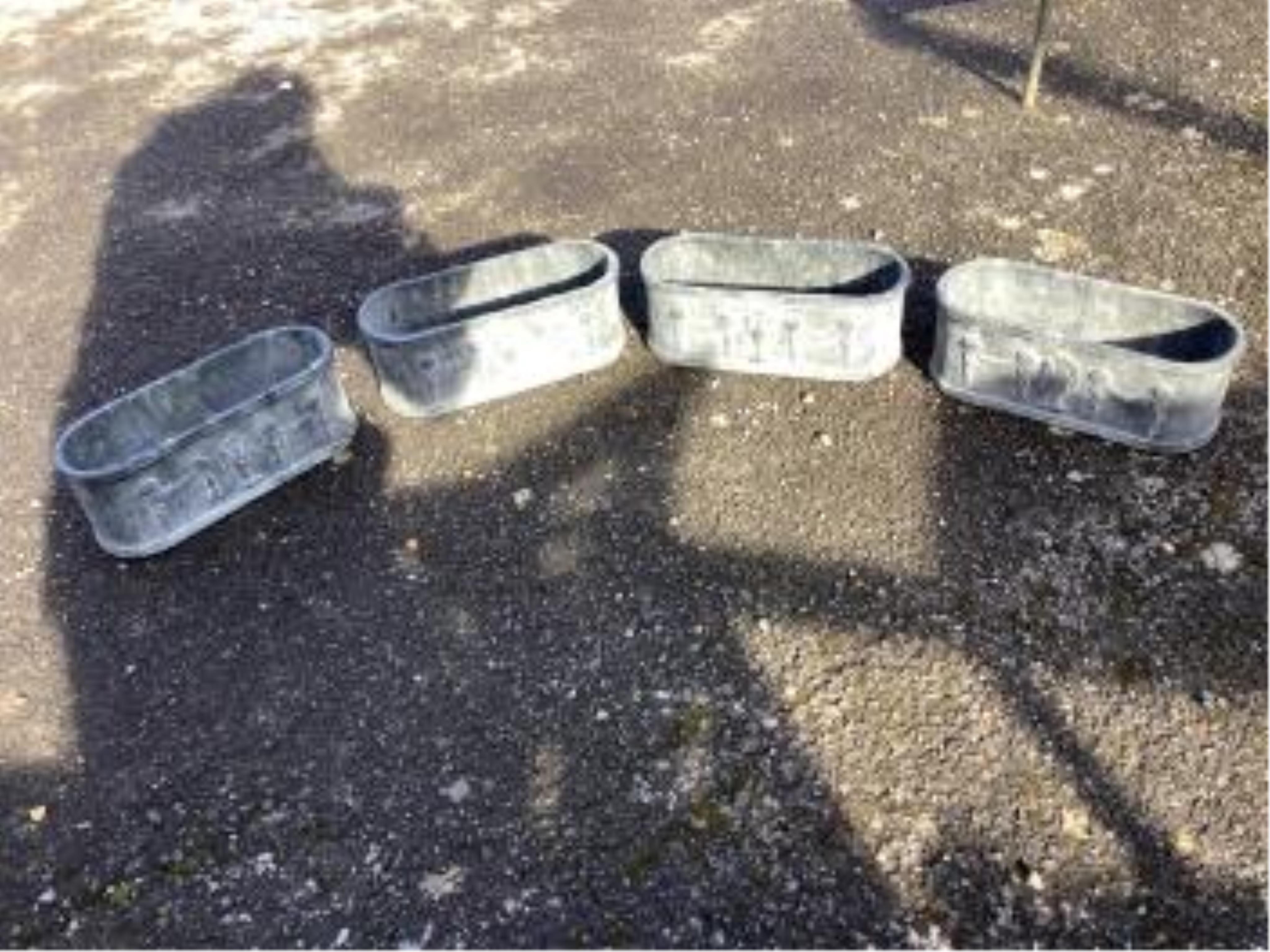 A set of four cast iron planters, width 36cm, and a pair of more ornate planters, width 48cm. Condition - weathered, otherwise good